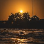 the sun is setting over a body of water