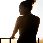 woman in black tank top standing near railings