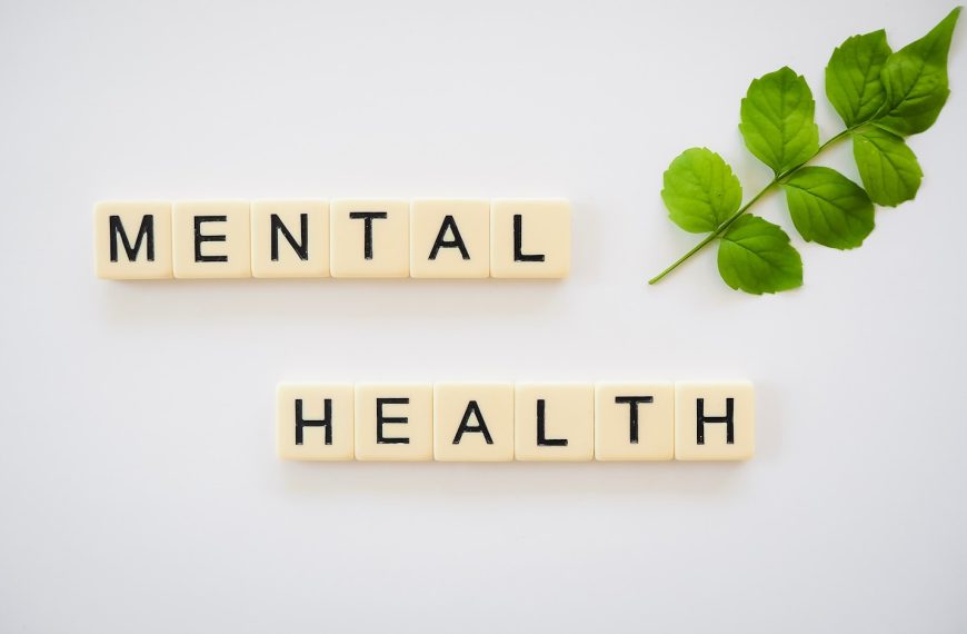 the word mental health spelled with scrabbles next to a green leaf