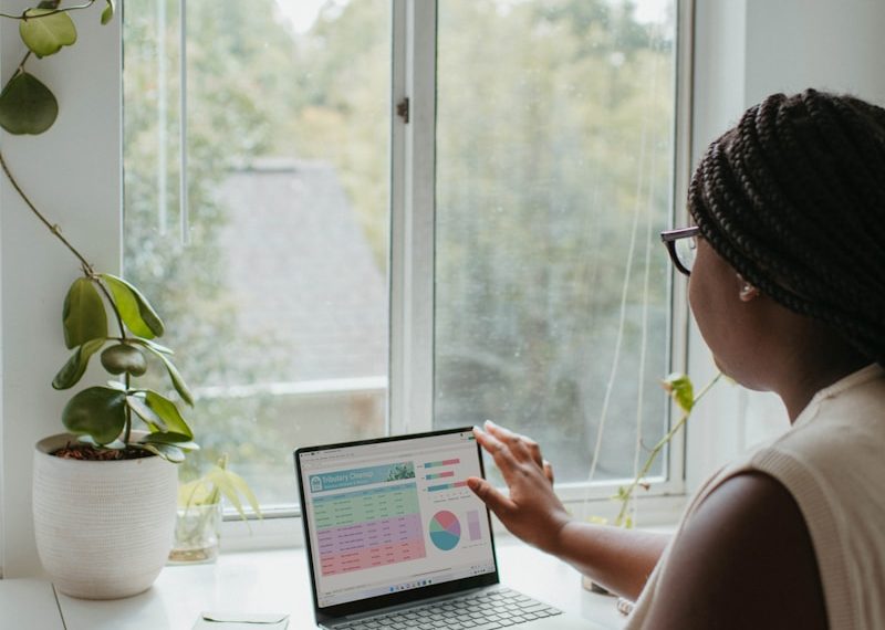 a woman sitting at a table using a laptop computer