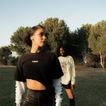 Two women posing in a grassy outdoor setting.