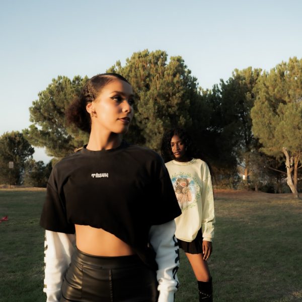 Two women posing in a grassy outdoor setting.