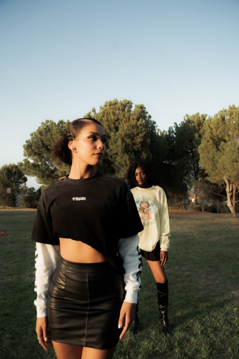 Two women posing in a grassy outdoor setting.