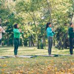 Four women practicing yoga in a park