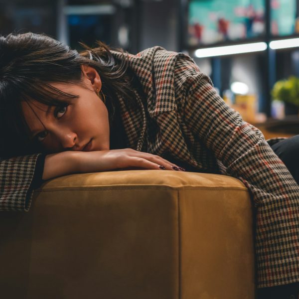 a woman sitting on a couch with her head on her hand