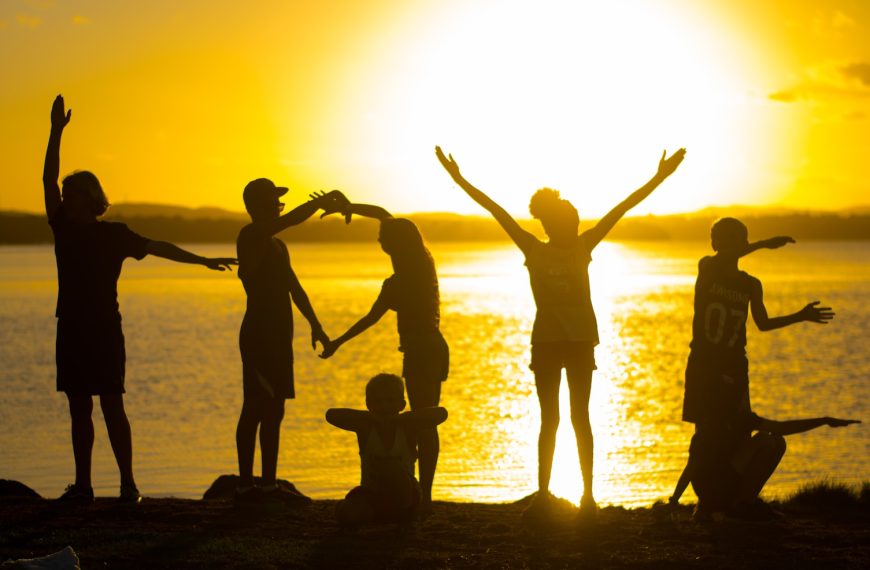 a group of people standing next to a body of water