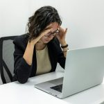 a woman sitting in front of a laptop computer